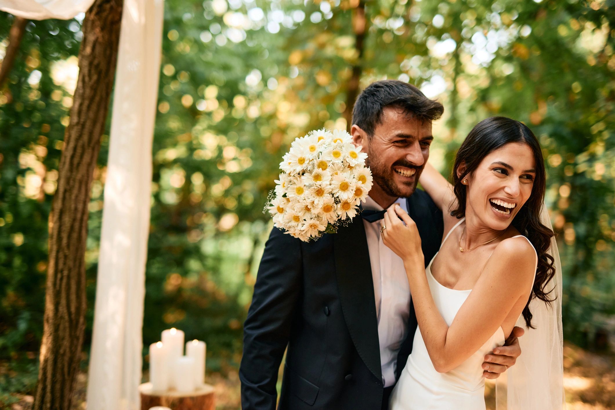 Newlyweds smiling outdoors on their wedding day